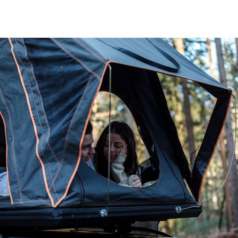 tentbox-cargo-hard-shell-roof-top-tent-black-open-rear-view-on-vehicle-with-couple-inside-in-nature