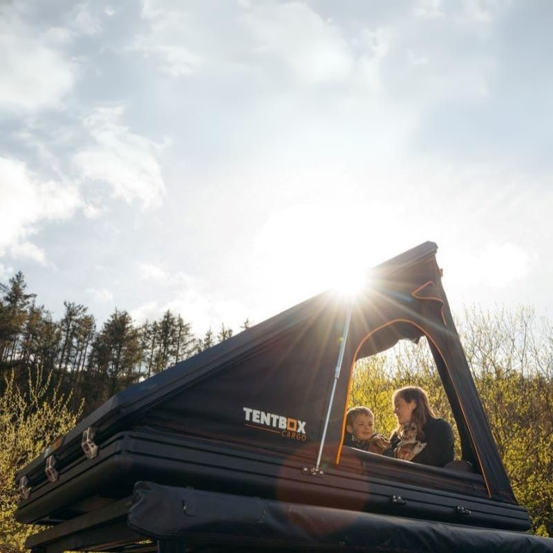 tentbox-cargo-hard-shell-roof-top-tent-black-open-side-view-on-vehicle-with-family-in-nature