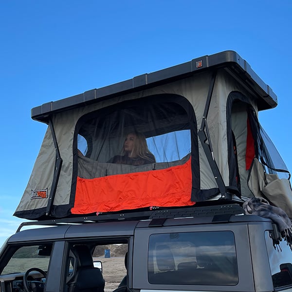 badass-tents-recon-pop-up-roof-top-tent-open-rear-side-view-with-person-inside-on-ford-bronco