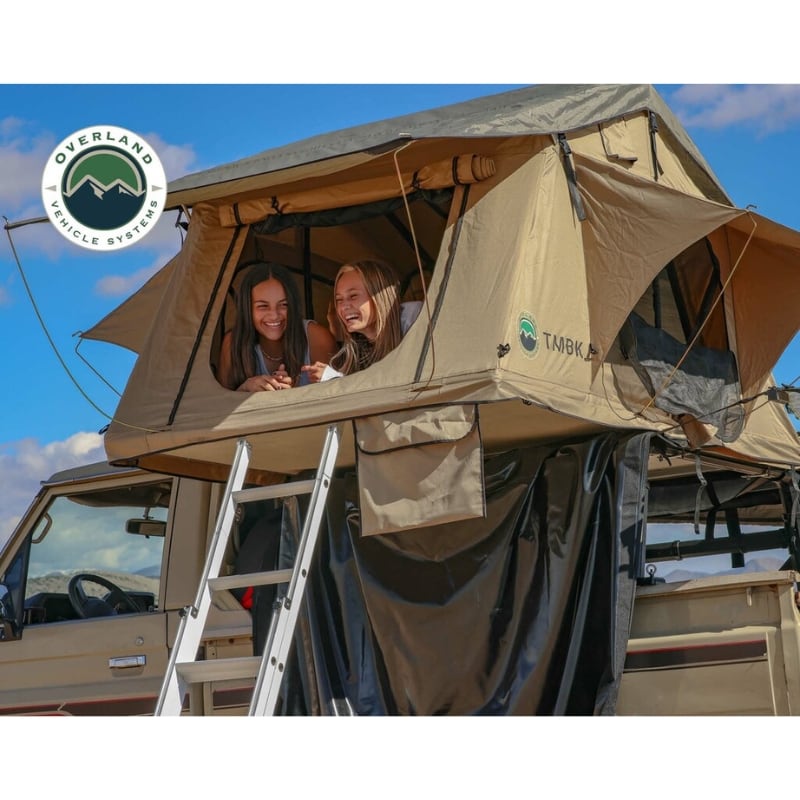 overland-vehicle-systems-tmbk-soft-shell-roof-top-tent-tan-open-entrance-view-with-two-persons-inside-on-top-of-toyota-land_cruiser-against-blue-sky